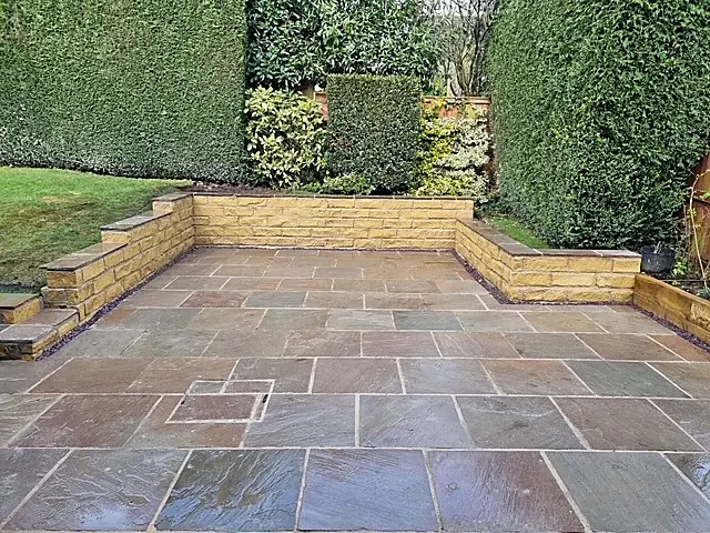 Sandstone patio with low stone retaining walls in a Huddersfield garden